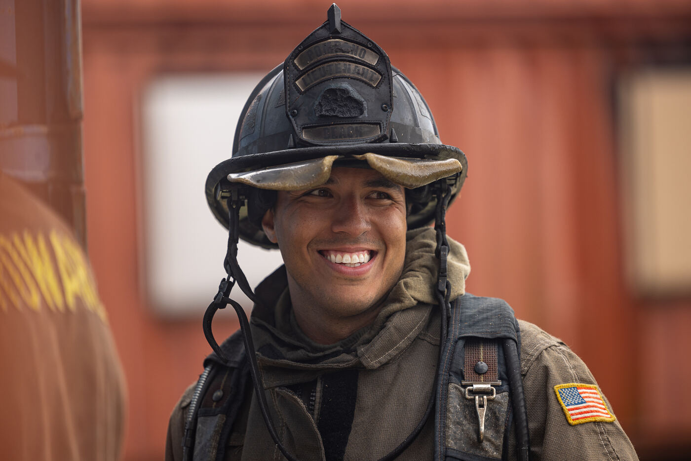 A crew of firefighters laughing together in turnout gear
