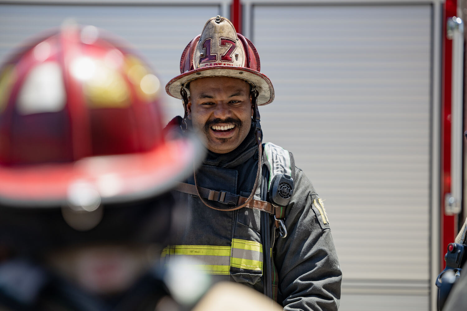 A wildland firefighter silhouetted against flames and smoke